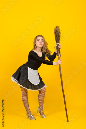 Sexy maid on broomstick in the studio, witches, evil spirits. © Ivan Zelenin