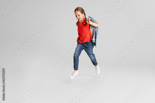 Happy kid, girl isolated on white studio background. Looks happy, cheerful, sincere. Copyspace. Childhood, education, emotions concept