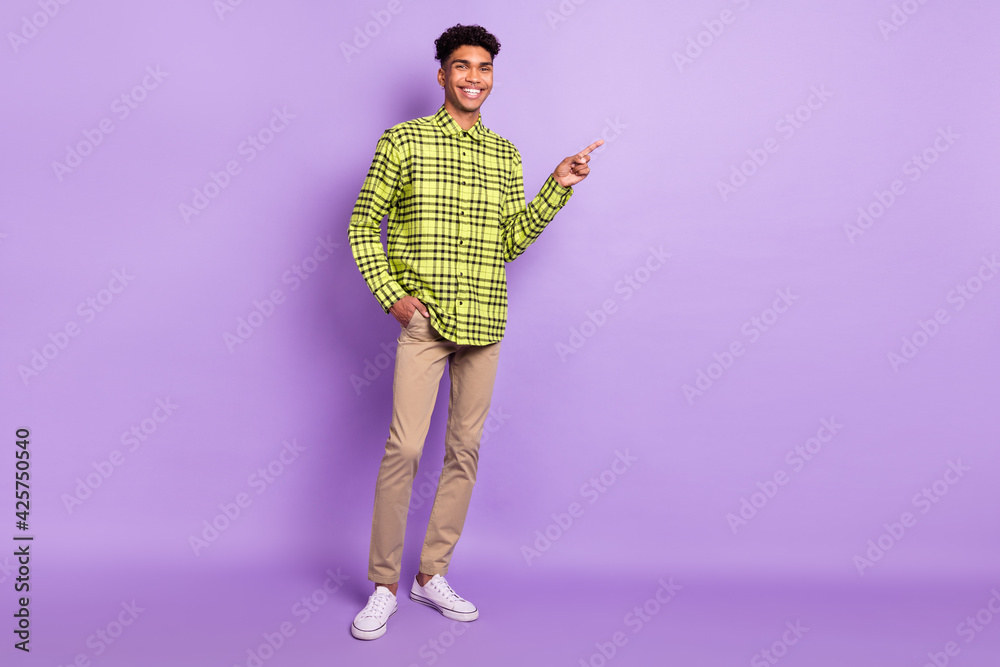 Full length body size view of attractive cheerful guy demonstrating copy space ad like isolated over violet purple color background Full length body size view of attractive cheerful guy demonstrating copy space ad like isolated over violet purple color background
