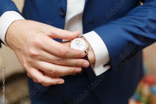 Man checks the time on his watch. The clock in his hands. Time run. Accuracy. What time is it? 