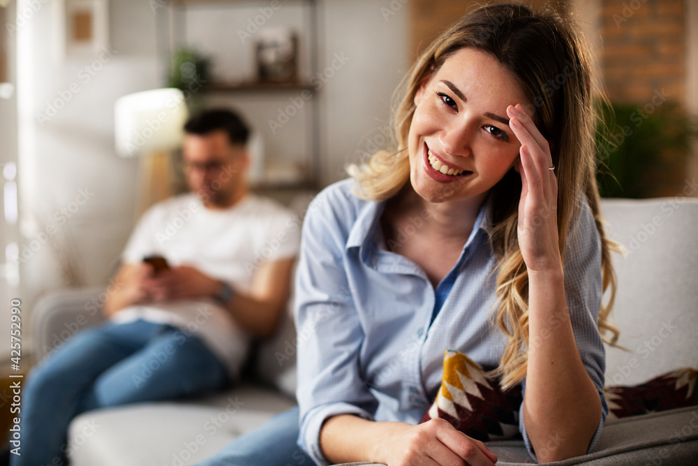Happy young woman using the phone at home. Excited woman enjoying in the living room Happy young woman using the phone at home. Excited woman enjoying in the living room