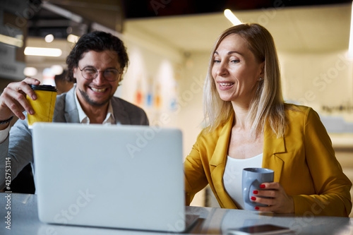 Close up of cheerful woman sitting near her colleague