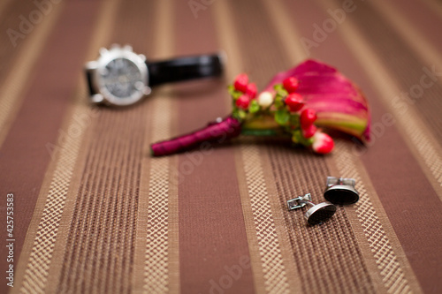 Groom's morning. Wedding accessories in red colors. Boutonniere, belt and wedding rings