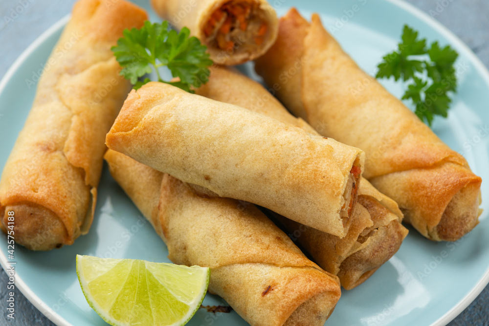 Fried spring rolls with sweet chili sauce and lime on plate Fried spring rolls with sweet chili sauce and lime on plate