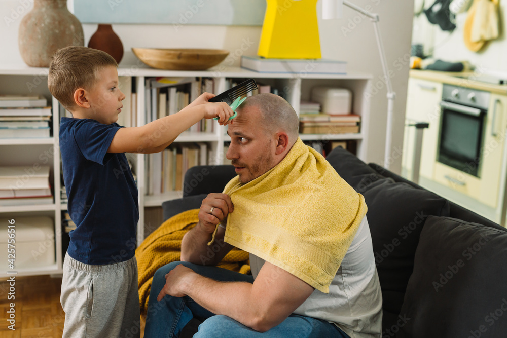 Obraz premium boy playing hairdresser with his father