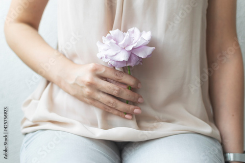 Woman holding elegant purple rose in her hand.