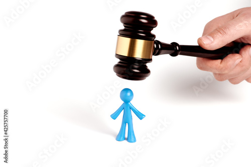 . Toy man and judge gavel isolated on white background. The concept of unfair judgments. Antipopular court. injustice photo