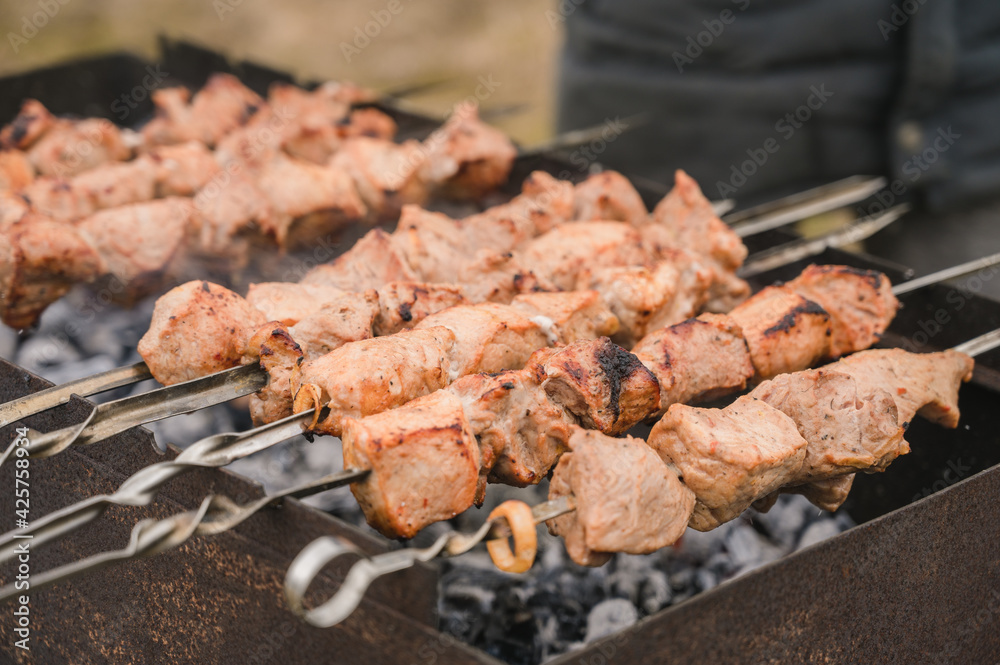 Traditional russian cuisine. Shashlik. Grilled marinated meat on skewers. Outdoor barbeque cooking. Tasty food.