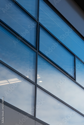 Rectangular windows, blue panes in a modern office building with a gray graphite wall 