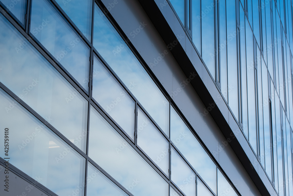 Rectangular windows, blue panes in a modern office building with a gray graphite wall Rectangular windows, blue panes in a modern office building with a gray graphite wall
