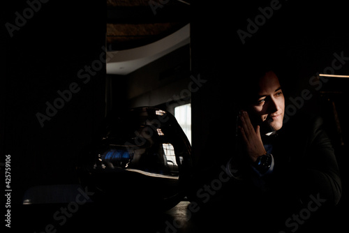 Close up of young groom is waiting for the wedding ceremony in a dark hotel room. Concept of groom morning © IVASHstudio