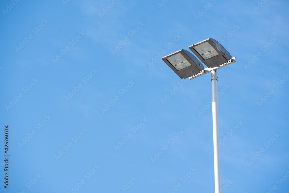 Double public lamp against the blue sky during the day Double public lamp against the blue sky during the day