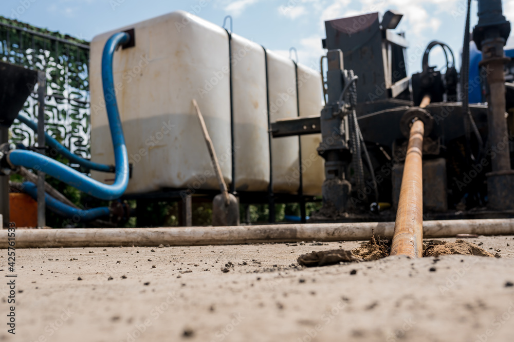 Low angle view of Horizontal directional drilling technology. Drilling machine work process. Trenchless laying of communications, pipes and water pipes. Close up