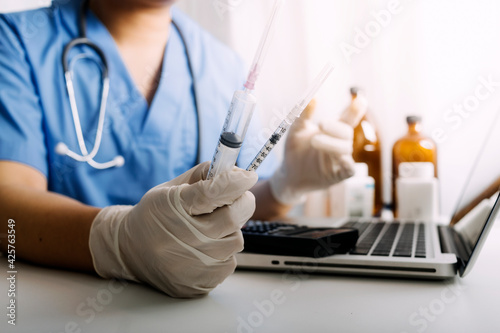 Concept fight against virus covid-19 corona virus  doctor or scientist in laboratory holding a syringe with liquid vaccines for children or older adults Concept diseases medical care science.