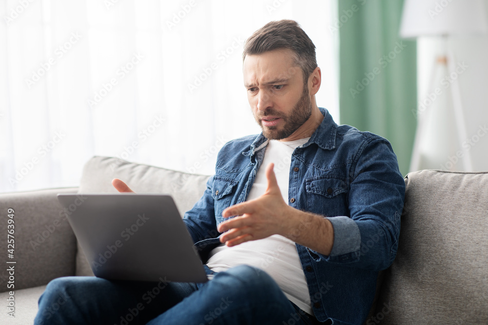 Angry man having video call with lover, using laptop Angry man having video call with lover, using laptop