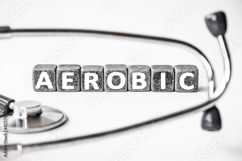 Stone block form word AEROBIC with stethoscope. White background. Medical concept. process that requires oxygen, aerobic exercise