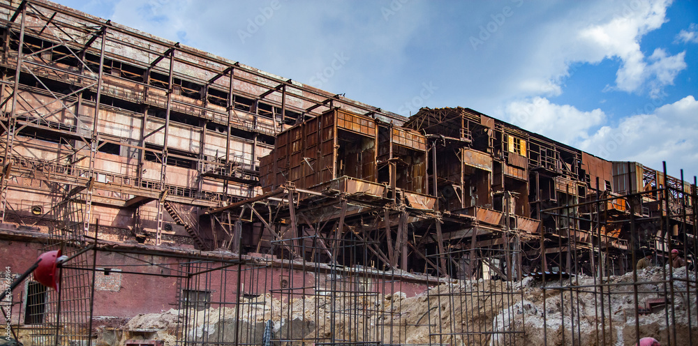 Demolition of outdated Soviet sulfuric acid plant industrial building. Outside view.