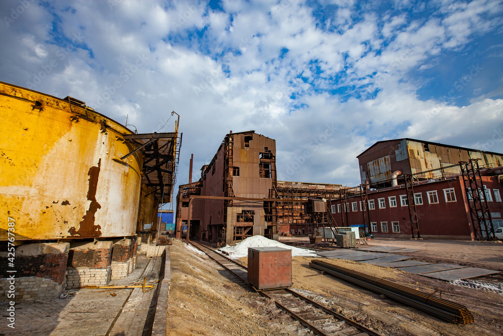 Demolition of outdated Soviet sulfuric acid plant industrial building. Outside view.