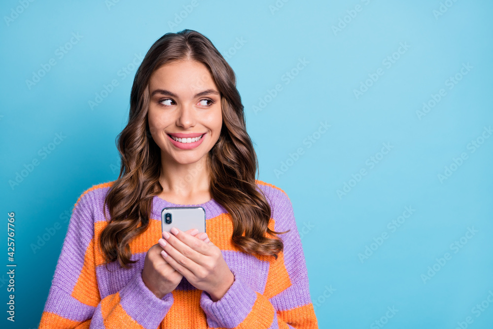 Photo of dreamy young lady hold phone dream look empty space isolated on pastel blue color background Photo of dreamy young lady hold phone dream look empty space isolated on pastel blue color background
