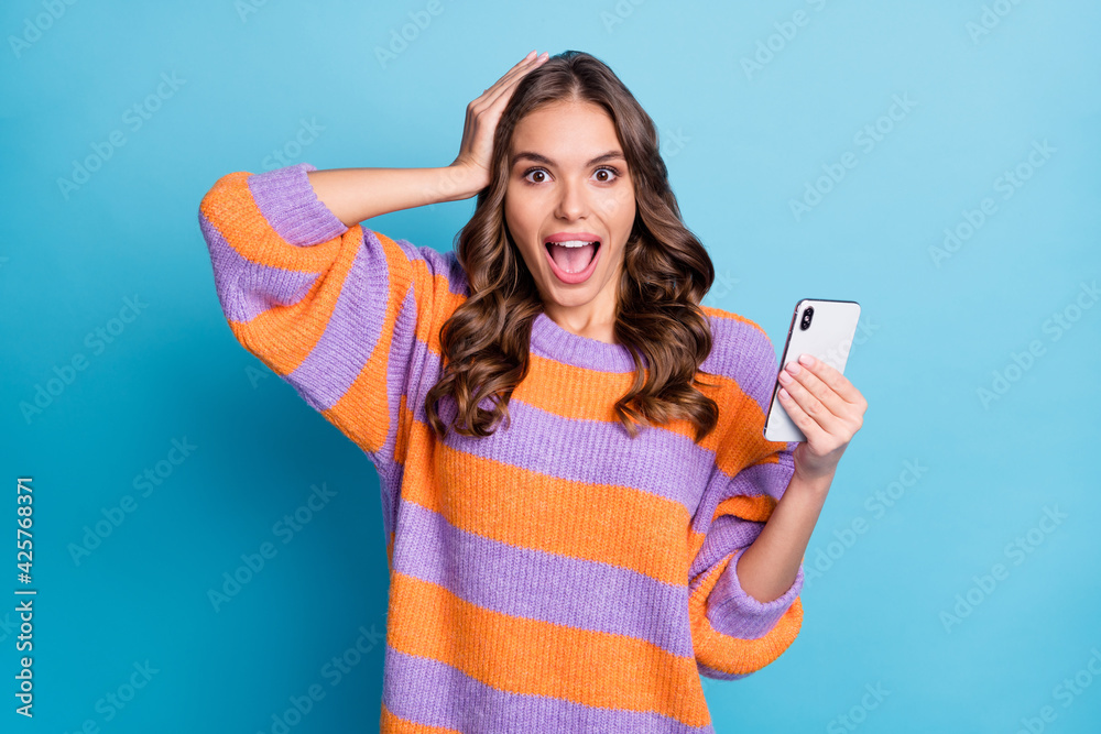 Naklejka premium Portrait of astonished girl arm on head open mouth unexpected news subscribe isolated on blue color background