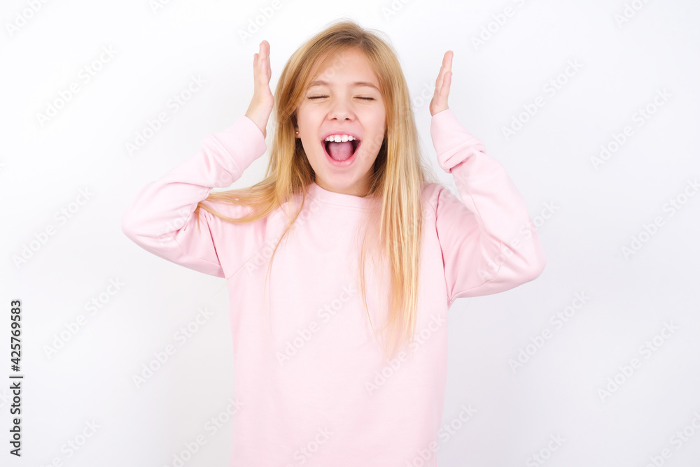 Beautiful caucasian blonde little girl wearing pink sweater goes crazy as head goes around feels stressed because of horrible situation