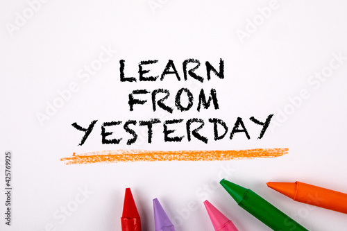 Learn from yesterday. Colored crayons on a white background photo