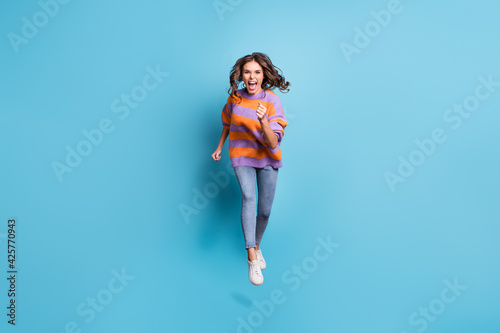 Full length portrait of astonished running fast girl open mouth shout isolated on blue color background