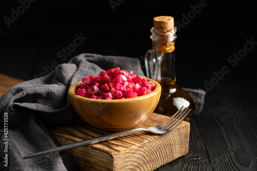 salad vinaigrette in a wooden cup on a dark background