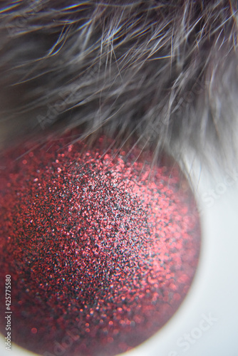 selective focus at the red ball with glitters on the surface with the fur