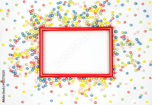 Red frame and multicolored candy on white background. Template for your design. Festive mock up