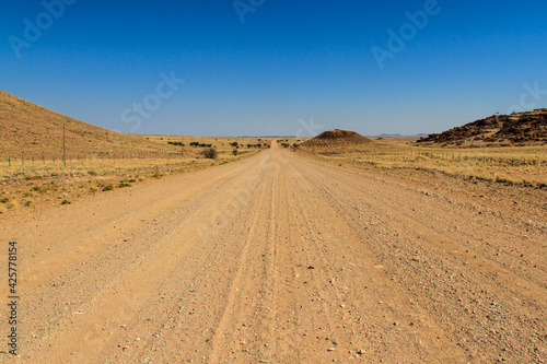 Straight gravel road through namib desert in Namibia
