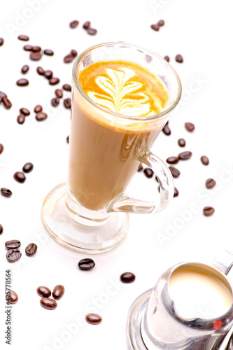 Close-up view of the Crema Coffee cappuccino In a clear glass and coffee beans on white background.shallow focus effect.