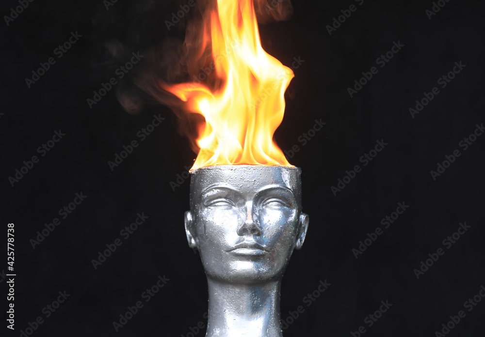 Fire on head.Mannequin head burns on a black background Fire on head.Mannequin head burns on a black background