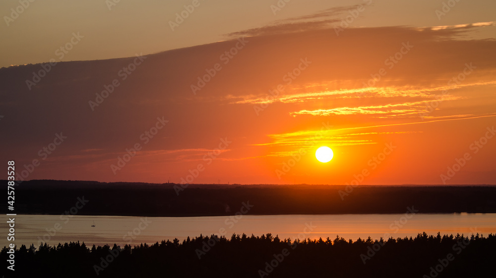 Colorful sunset on lake Usma in Latvia. Above the tops of the trees. Colorful sunset on lake Usma in Latvia. Above the tops of the trees.