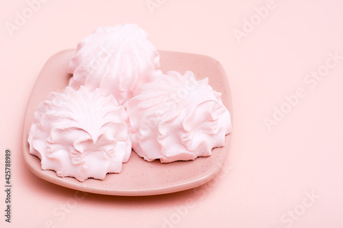 The concept is pink. Pink marshmallows on a saucer on a pink background