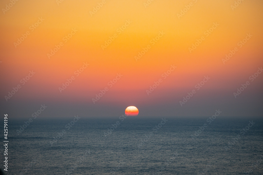 海から日の出中の太陽