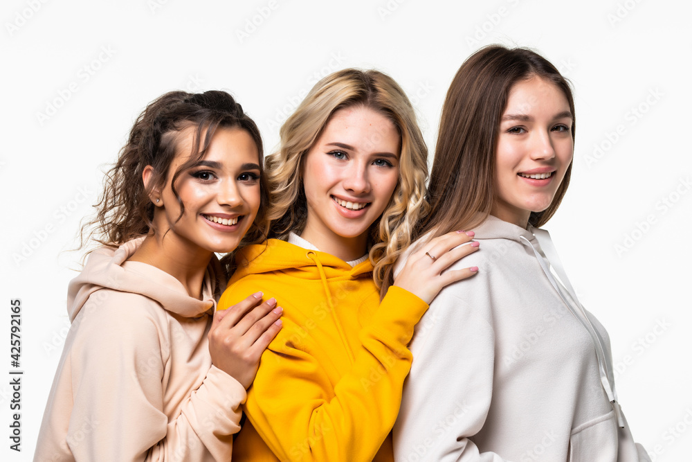 Three young women in casual clothing standing isolated on white background Three young women in casual clothing standing isolated on white background