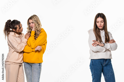 Portrait of three upset casual girls standing together querrel or bother over white background