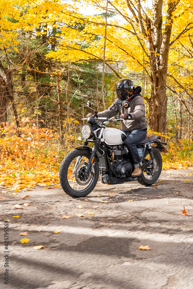 Young man riding his motorcycle in the autumn in Canada