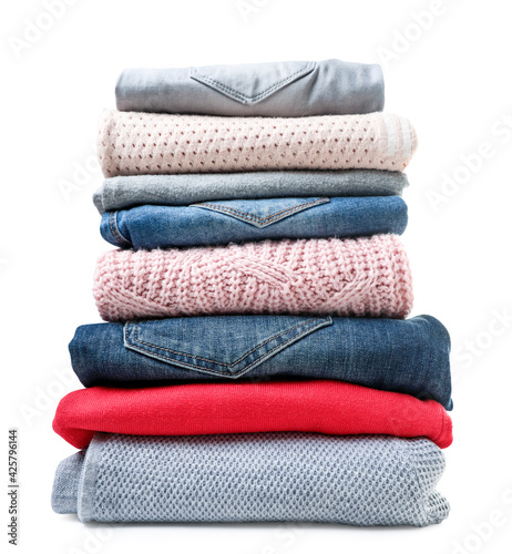 Obraz na plátně Stack of clothes sweaters and jeans on a white background