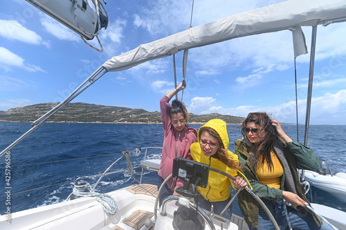 Three strong girls sailing with a boat in the ocean