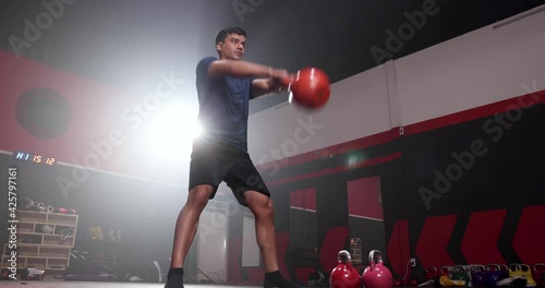 Healthy young men exercise with kettlebell to build muscle strength.