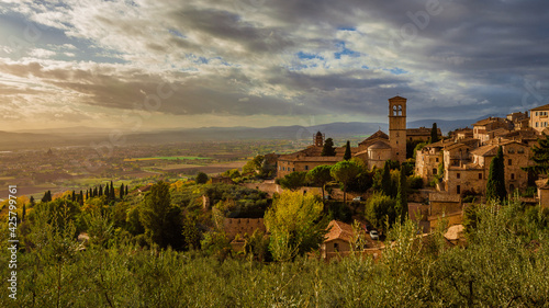 View of the Assisi historic center ancient buildings and nearby countryside at sunset with beautiful clouds
