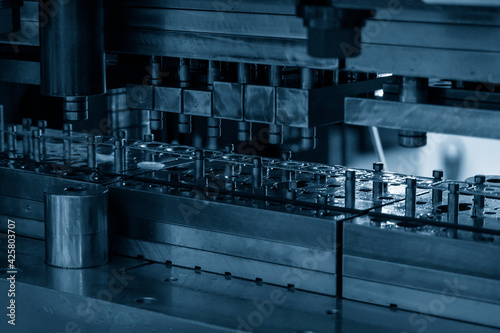 Close-up scene of progressive die operation. The metal work processing by stamping die. photo