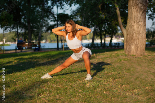 Muscular fitness woman doing pilates workout at the park