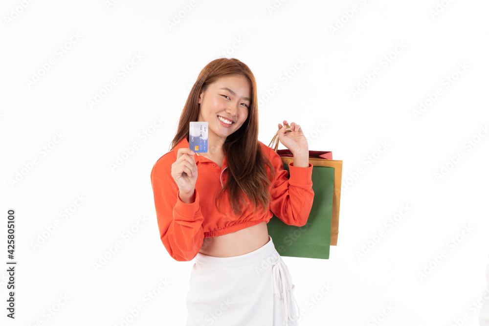 Young beautiful Asian woman smiling happy on white background holding shopping bags. Asian girl in studio, pose feeling happy with shopping bags in studio light portrait. Young beautiful Asian woman smiling happy on white background holding shopping bags. Asian girl in studio, pose feeling happy with shopping bags in studio light portrait.