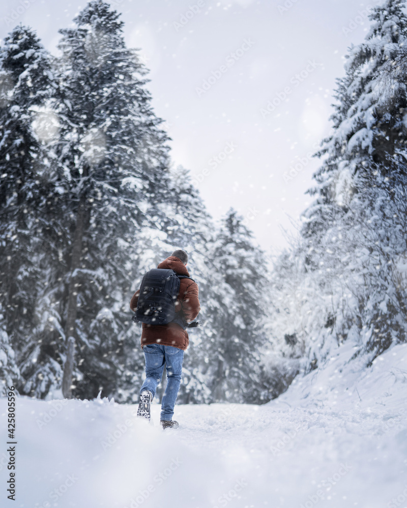 Homme de dos marchant dans la neige