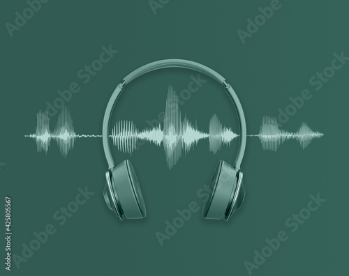 Modern headphones and audio waveform on green background