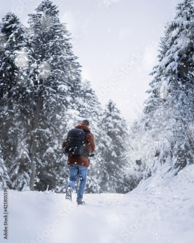 Homme de dos marchant dans la neige