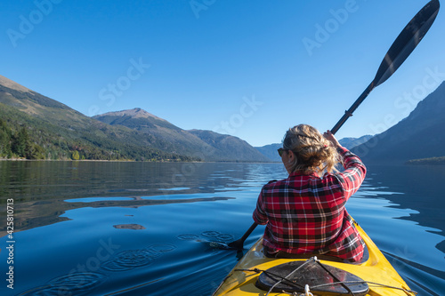 Young woman paddling a kayak touring the lakes of the National Park. Patagonia, Argentina. photo